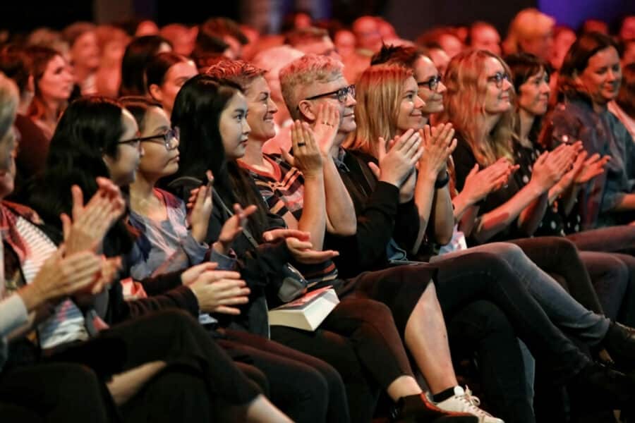 Happy audience members at the Sydney Writers' Festival clapping.