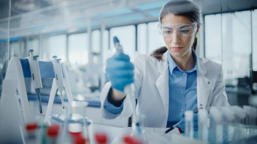 Female scientist in a lab working with a pipette.