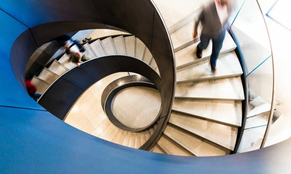 Business people walking down a spiral staircase