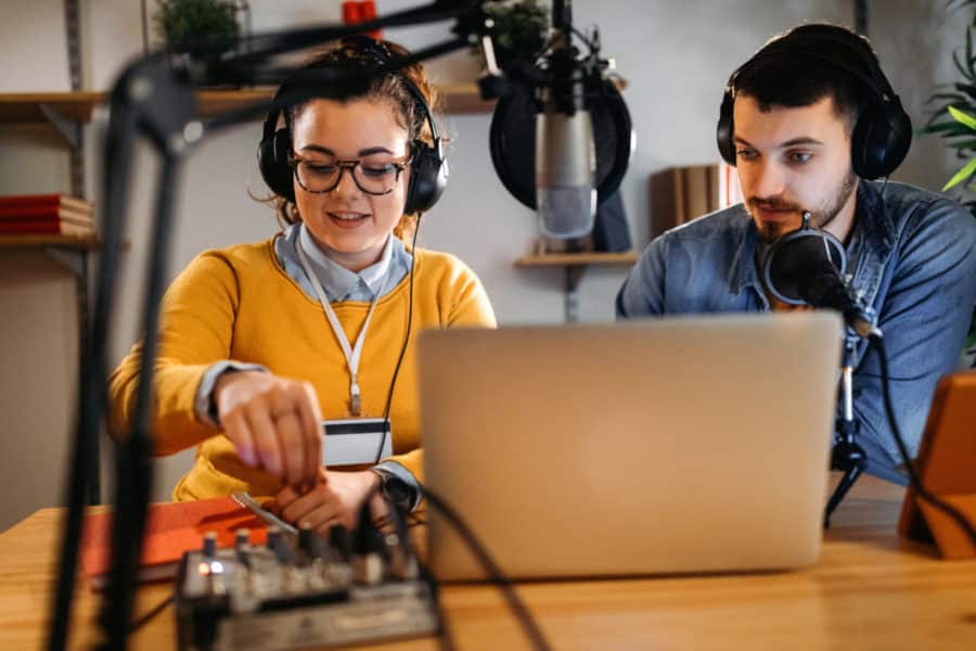 Photo of two young people making a podcast.