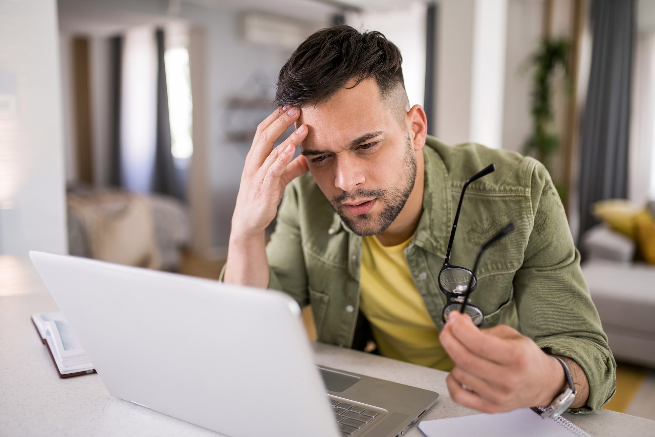 Man squinting to read from a laptop screen.